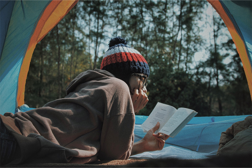 Woman reading in a tent