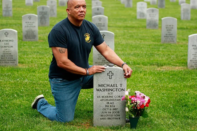 Man kneeling in front of a grave