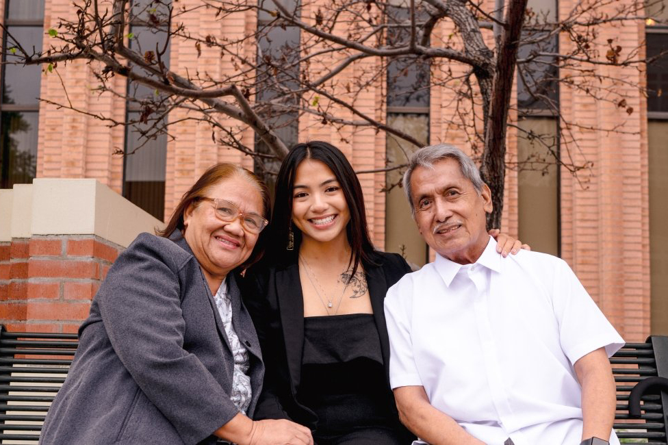 Ella Rae Bautista with parents seated outside